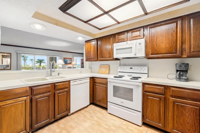 a kitchen with cabinets appliances a sink and a window