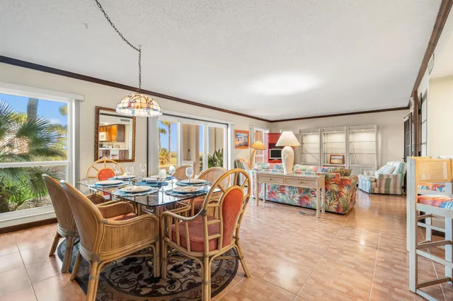 a dining room with furniture and a floor to ceiling window