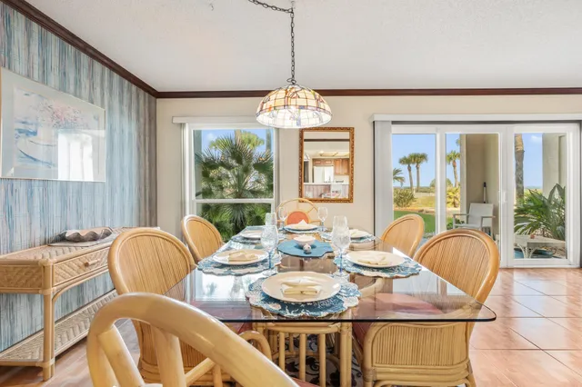 a dining room with furniture a chandelier and wooden floor