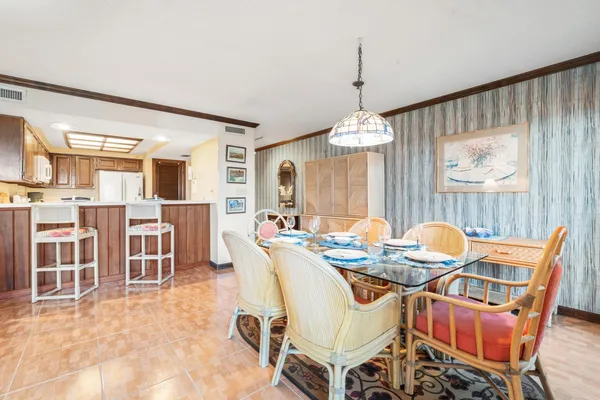 a dining room with furniture a chandelier and wooden floor