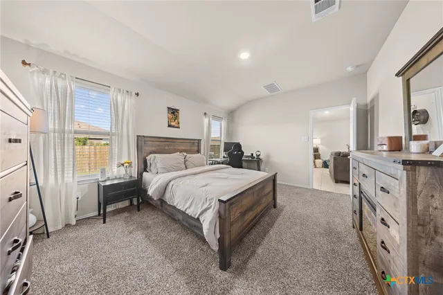 a spacious bedroom with a large bed and a dresser