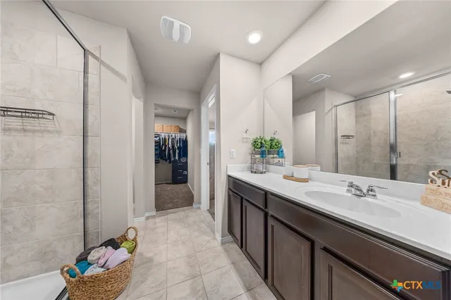 a bathroom with a double vanity sink mirror and shower