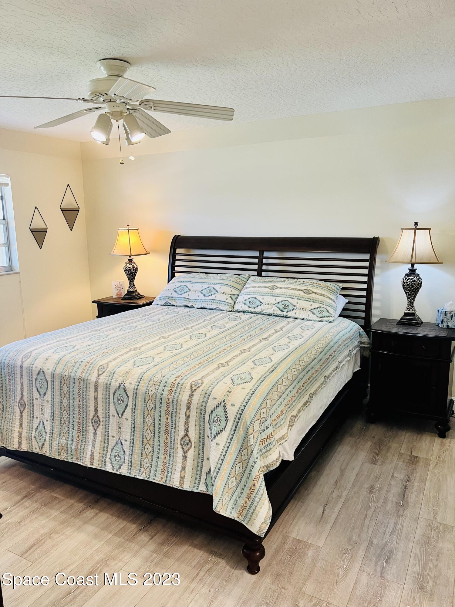 416 School Road, Unit 204 Indian Harbour Beach, FL 32937 - Photo 12 of 14 a bed sitting in a bedroom next to a lamp