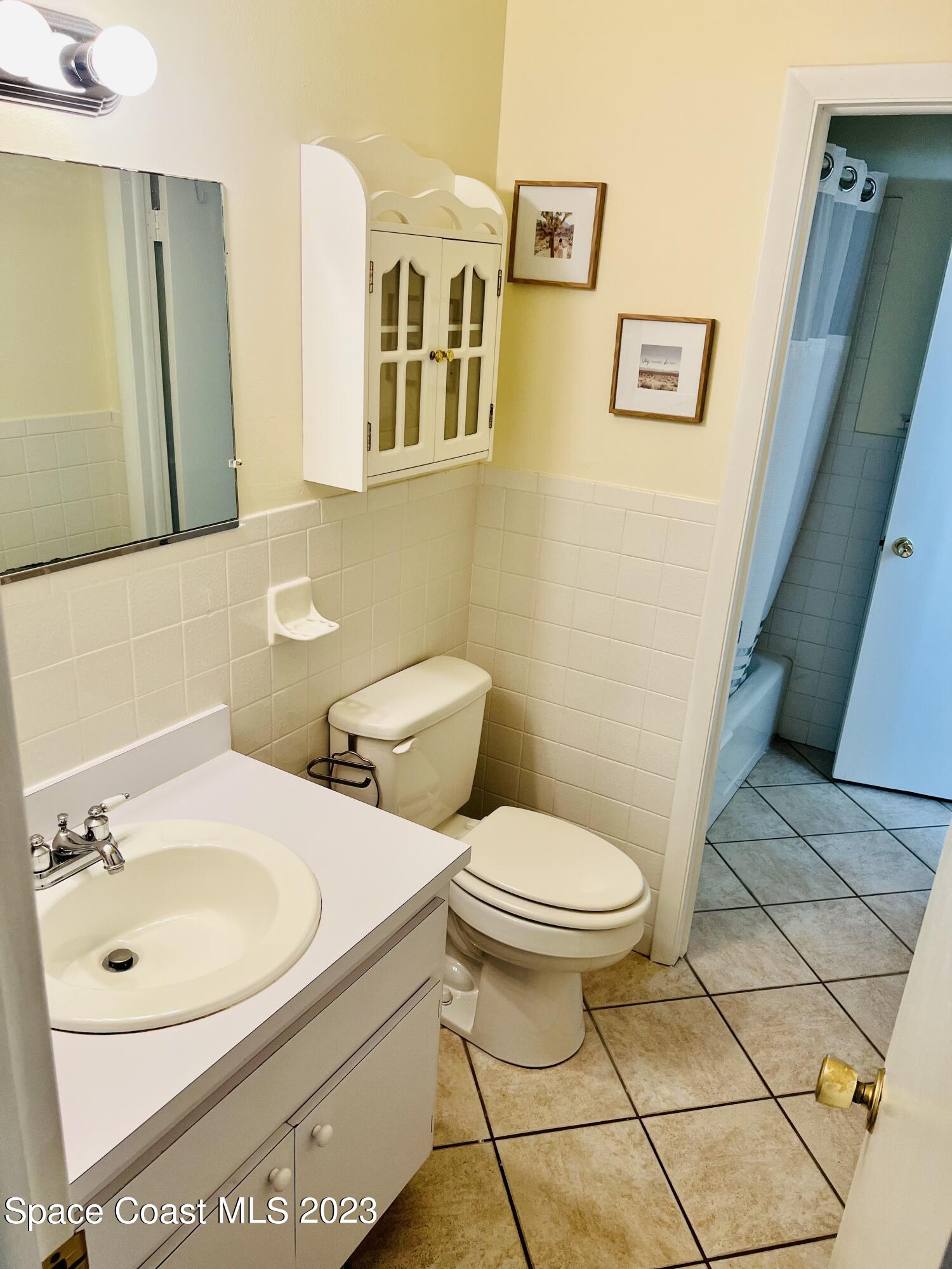 416 School Road, Unit 204 Indian Harbour Beach, FL 32937 - Photo 13 of 14 a bathroom with a sink toilet and mirror