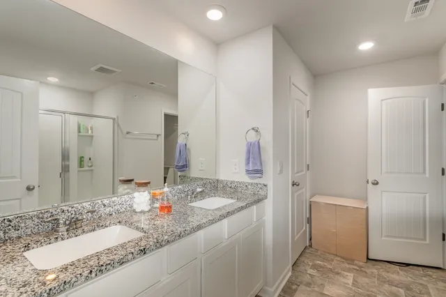 a bathroom with a granite countertop sink and a mirror