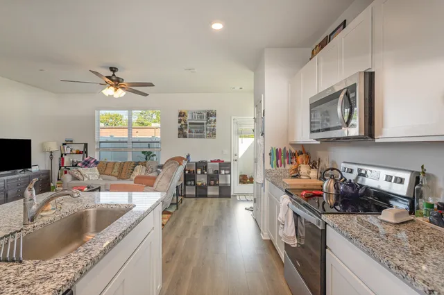 a kitchen with stainless steel appliances granite countertop a sink stove top oven and cabinets