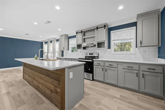 a kitchen with stainless steel appliances granite countertop a sink stove and cabinets