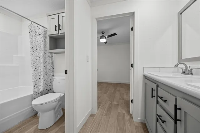 a bathroom with a granite countertop sink a toilet and shower
