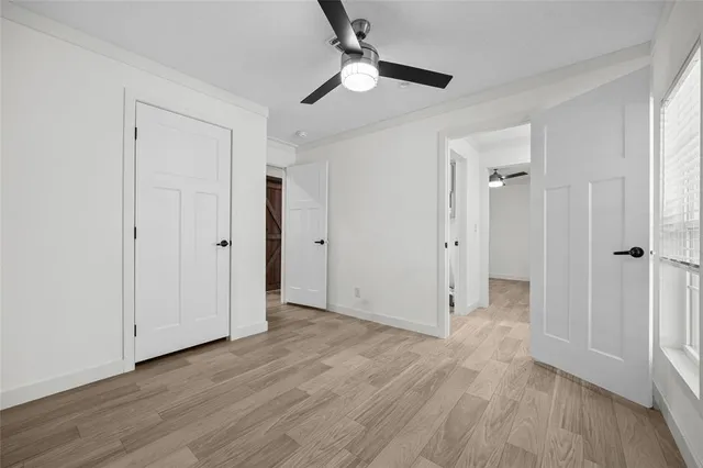 an empty room with wooden floor a ceiling fan
