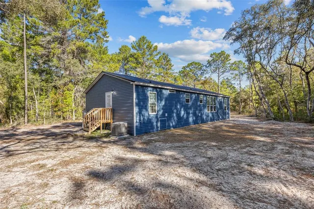 a view of backyard with a small cabin and wooden fence