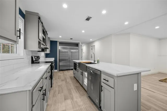 a kitchen with stainless steel appliances lots of counter space and wooden floor