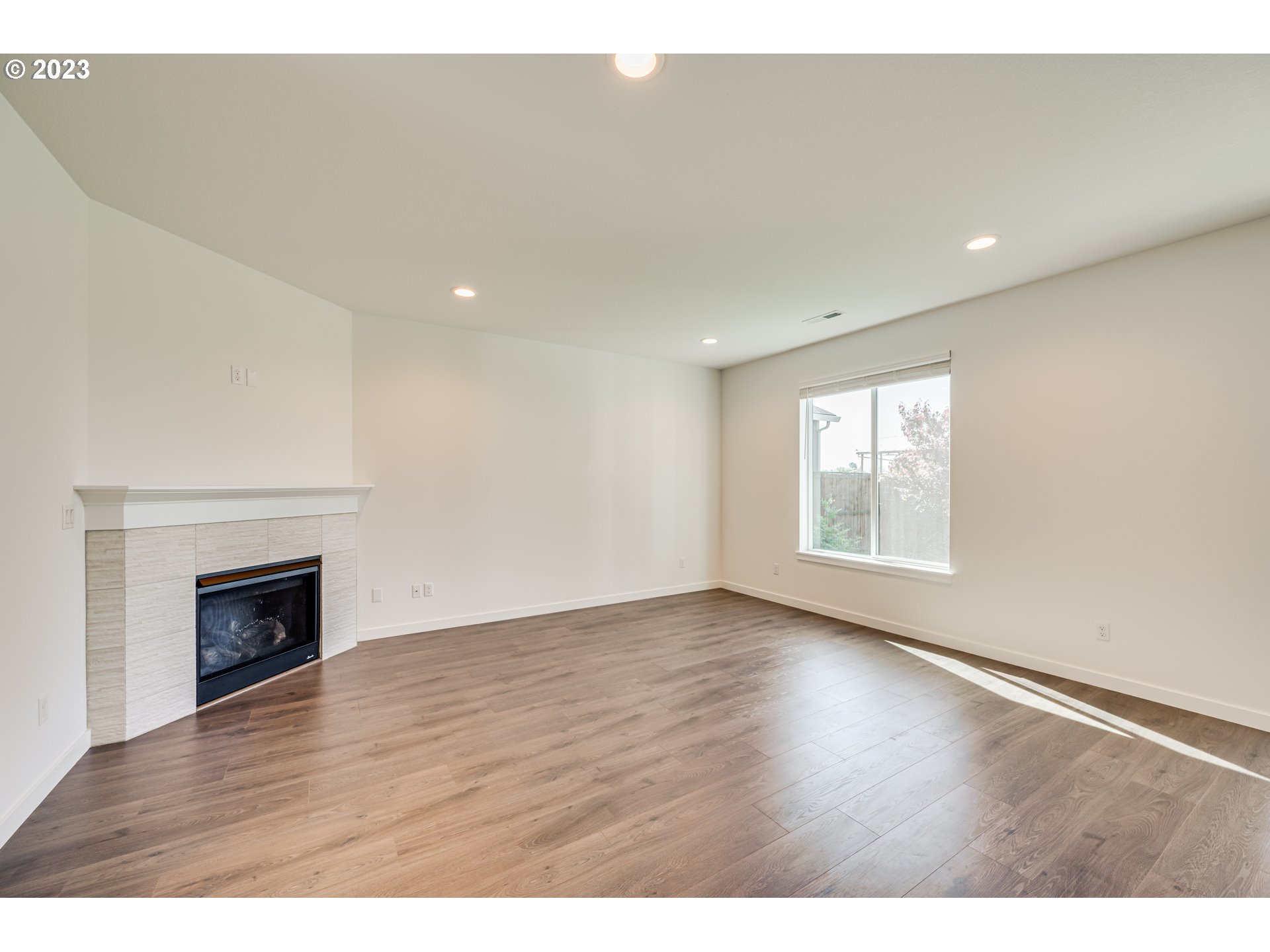 8603 North 1st Street Ridgefield, WA 98642 - Photo 15 of 33 a view of an empty room with wooden floor fireplace and a window