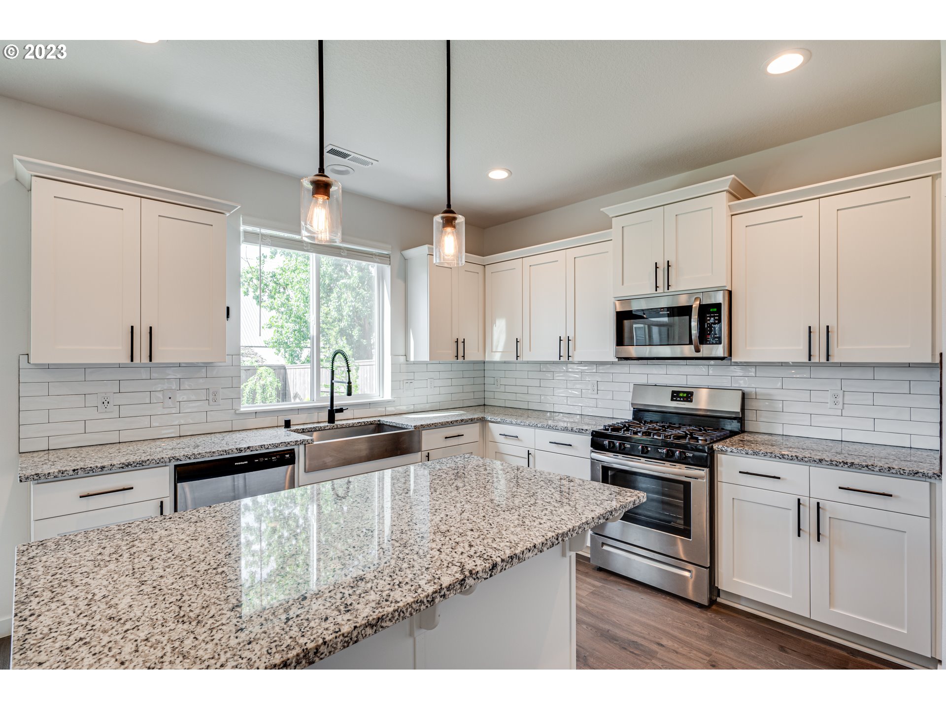 8603 North 1st Street Ridgefield, WA 98642 - Photo 4 of 33 a kitchen with stainless steel appliances granite countertop a sink a stove and a microwave