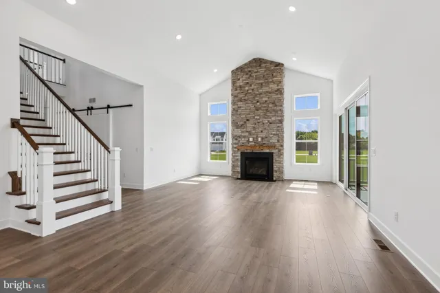 a view of empty room with fireplace and wooden floor