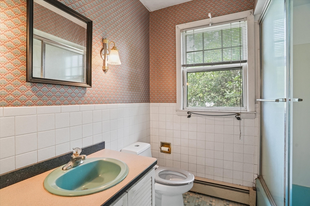 57 Olive Street Methuen, MA 01844 - Photo 13 of 38 a bathroom with a toilet a sink and mirror