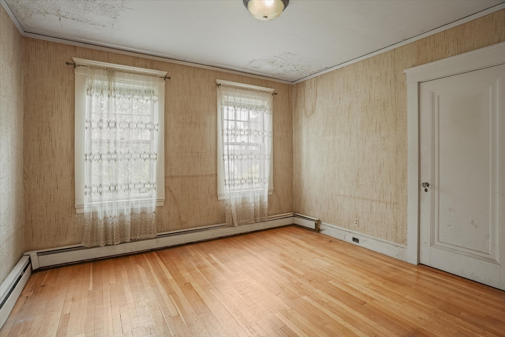 57 Olive Street Methuen, MA 01844 - Photo 14 of 38 a view of an empty room with wooden floor and a window