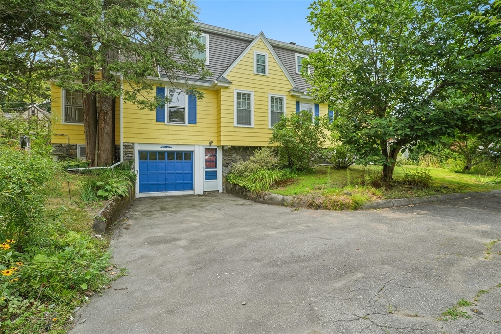 57 Olive Street Methuen, MA 01844 - Photo 30 of 38 a front view of a house with a yard and garage