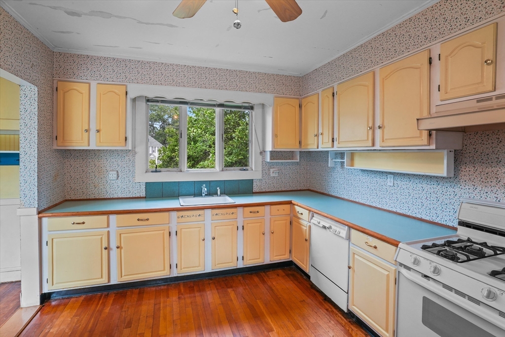 57 Olive Street Methuen, MA 01844 - Photo 4 of 38 a kitchen with granite countertop white cabinets and a wooden floor
