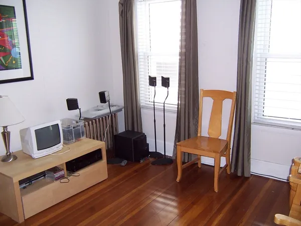 a view of a bedroom with furniture and wooden floor