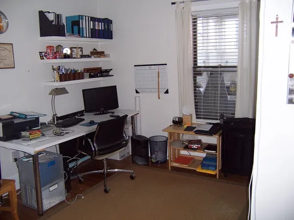 a view of a workspace with furniture and a window