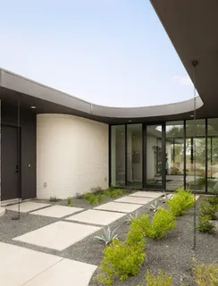 a living room with furniture potted plant and a large window