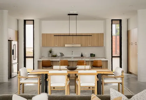a living room with furniture large windows and wooden floor