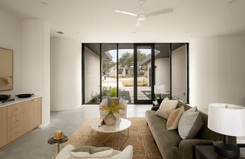 a view of a dining room and livingroom with furniture wooden floor a chandelier