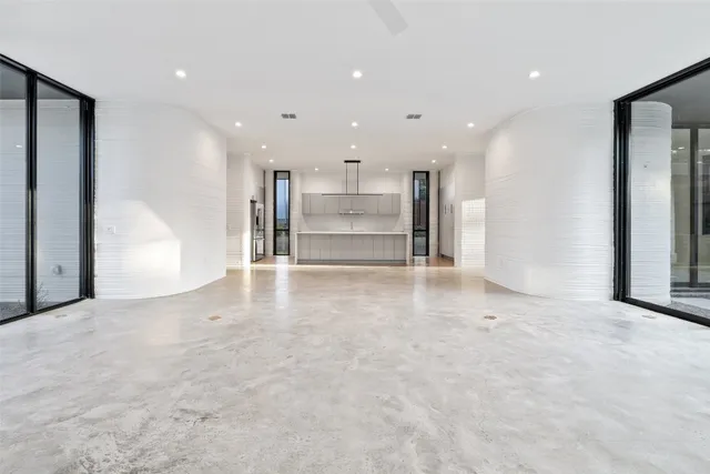 a view of a big room with a refrigerator and windows
