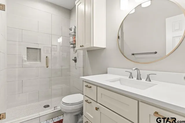 a bathroom with a sink a toilet and shower