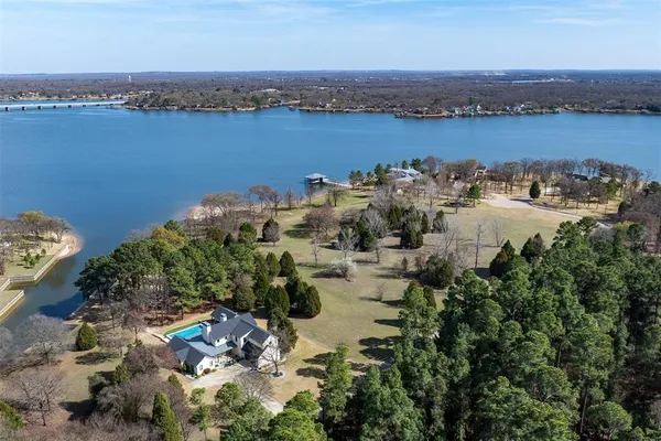 an aerial view of ocean and residential houses with outdoor space