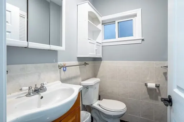 a bathroom with a sink a toilet and mirror