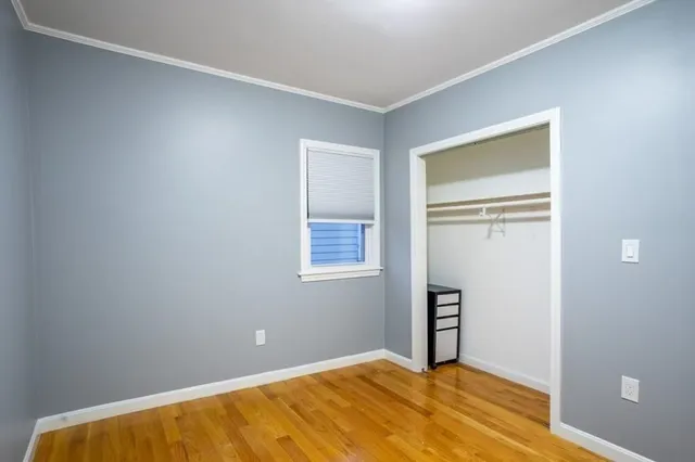 a view of an empty room with closet and a window