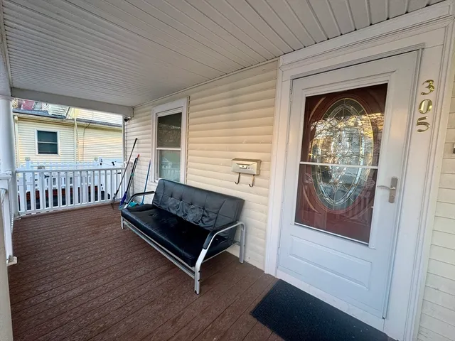 a view of a brick house with wooden deck