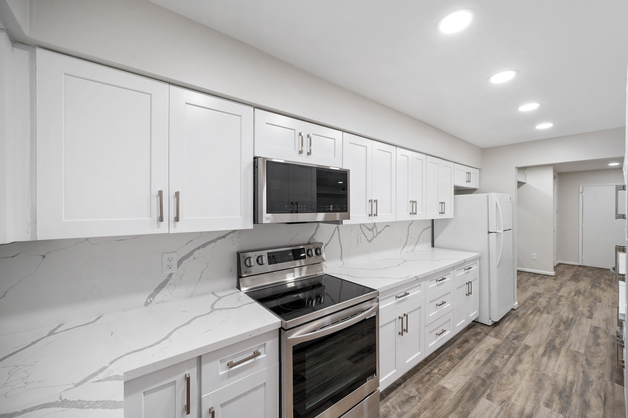 357 North Post Oak Lane, Unit 101 Houston, TX 77024 - Photo 4 of 19 The kitchen features TONS of counterspace, quartz countertops, plenty of wooden cabinetry, and recessed lighting.