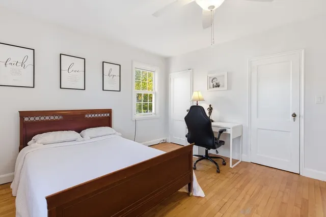 a bedroom with a bed a chandelier and chair