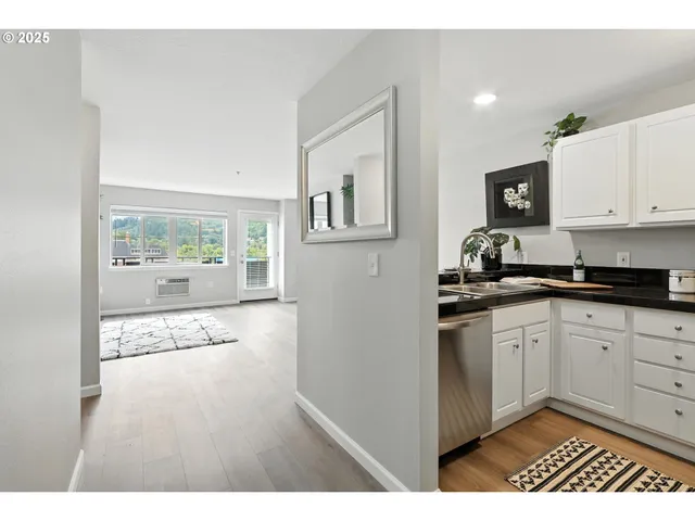 a open kitchen with granite countertop white cabinets and black appliances