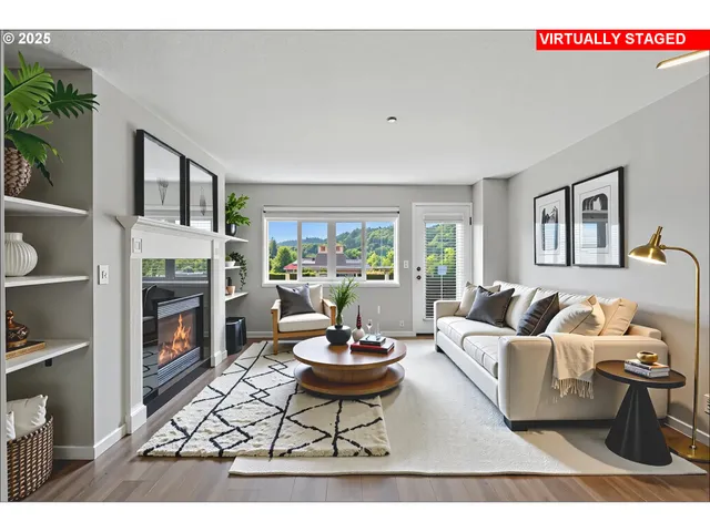 a living room with furniture a fireplace and a large window