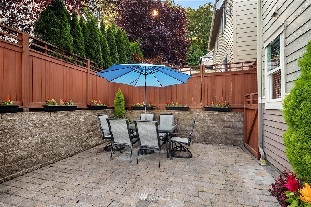 555 Alpine Ridge Place Northwest Issaquah, WA 98027 - Photo 14 of 31 a view of a patio with table and chairs under an umbrella