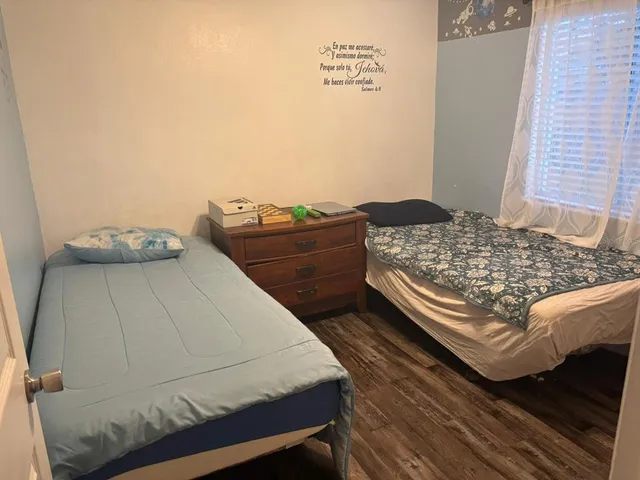 a bedroom with a bed and two windows