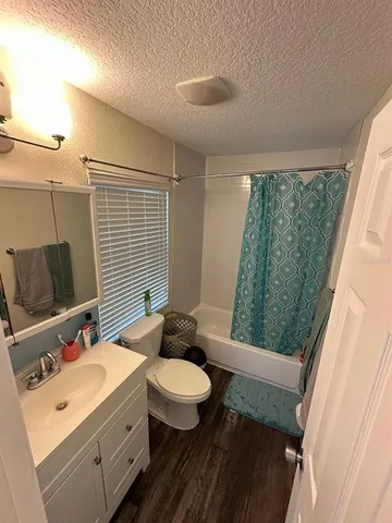 a bathroom with a granite countertop sink toilet a mirror and shower