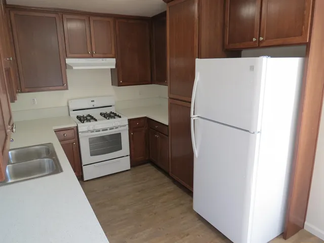 a kitchen with a refrigerator sink stove and cabinets