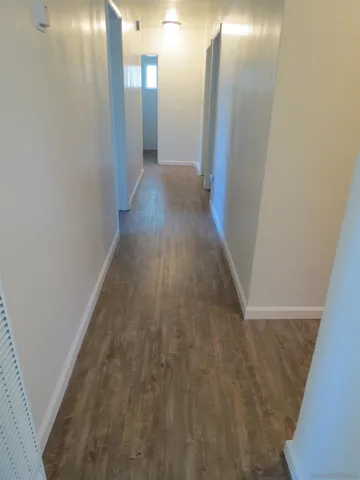 a view of a hallway with wooden floor