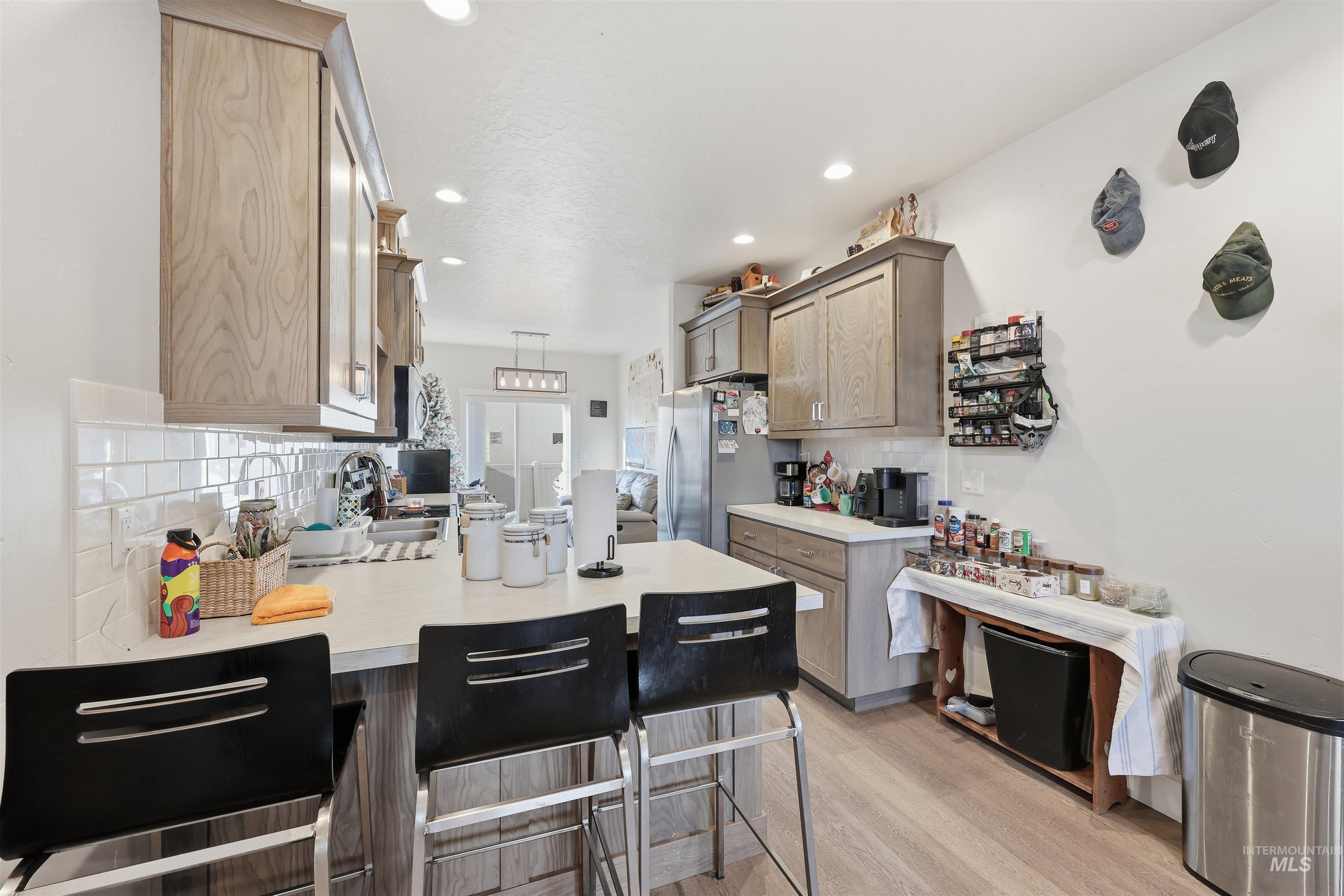 6341 South Ruddsdale Avenue Boise, ID 83709 - Photo 17 of 41 Kitchen featuring a breakfast bar area, a peninsula, light countertops, tasteful backsplash, and recessed lighting