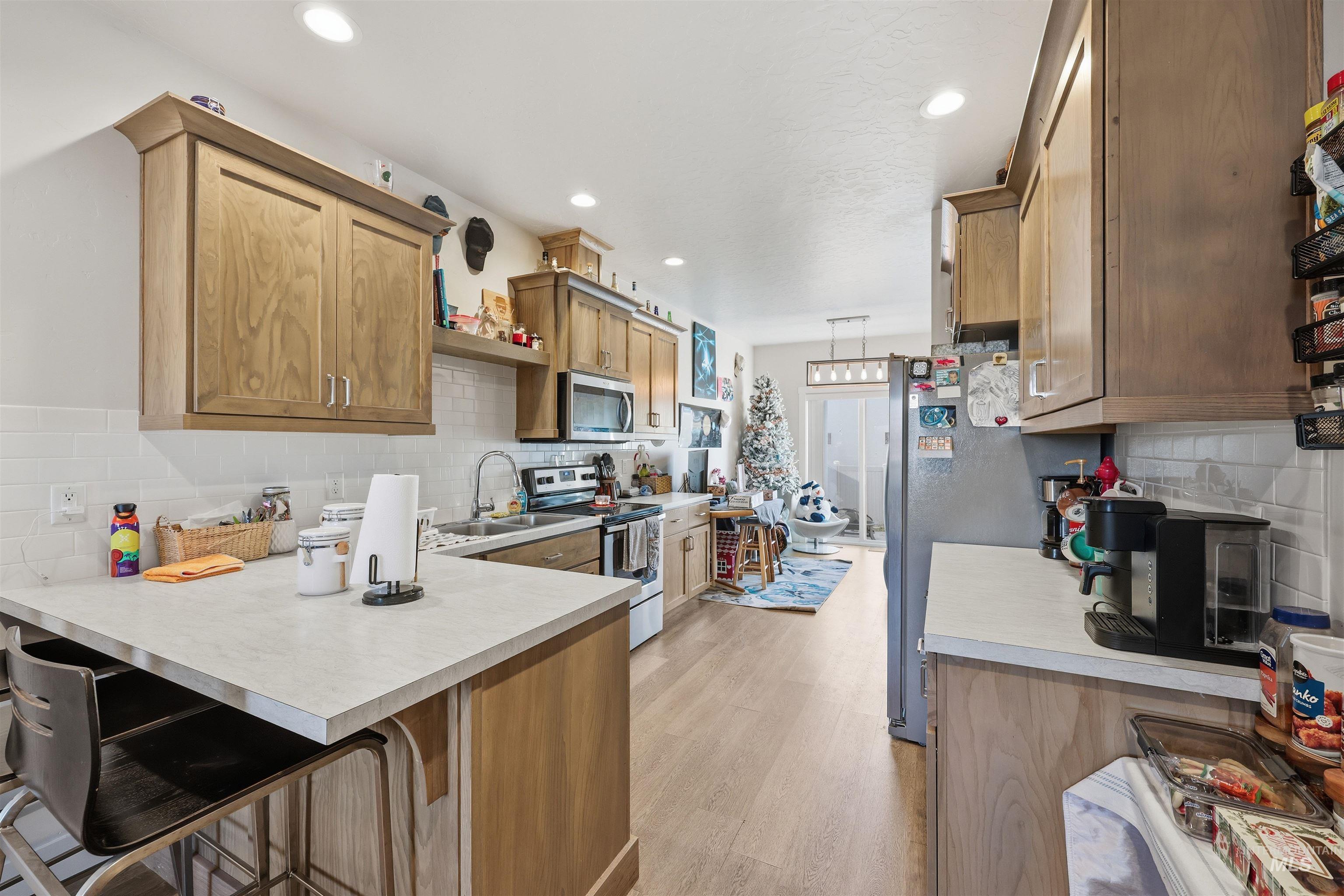 6341 South Ruddsdale Avenue Boise, ID 83709 - Photo 18 of 41 Kitchen with a breakfast bar, stainless steel appliances, a peninsula, backsplash, and recessed lighting
