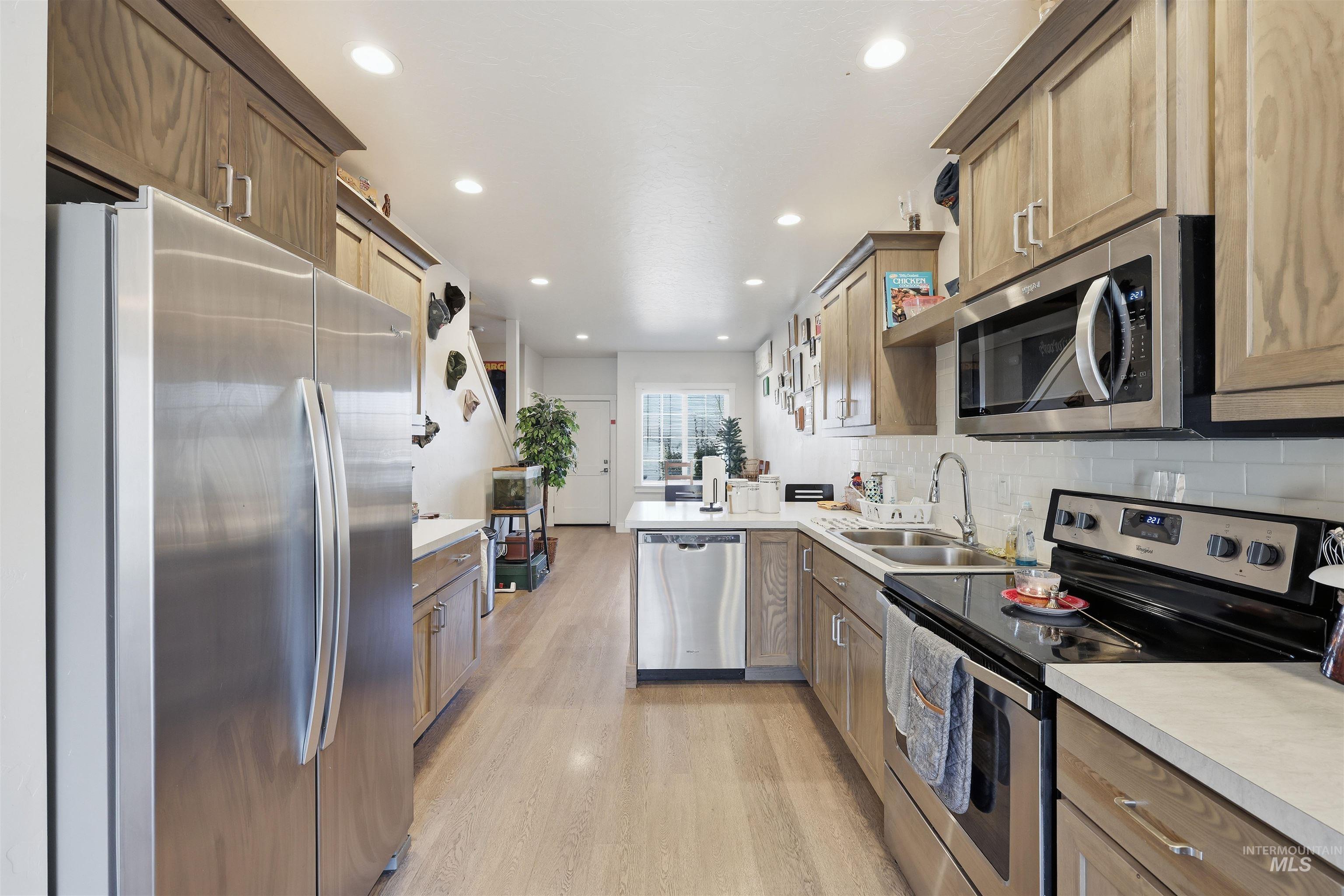 6341 South Ruddsdale Avenue Boise, ID 83709 - Photo 19 of 41 Kitchen featuring stainless steel appliances, light countertops, a peninsula, brown cabinetry, and recessed lighting