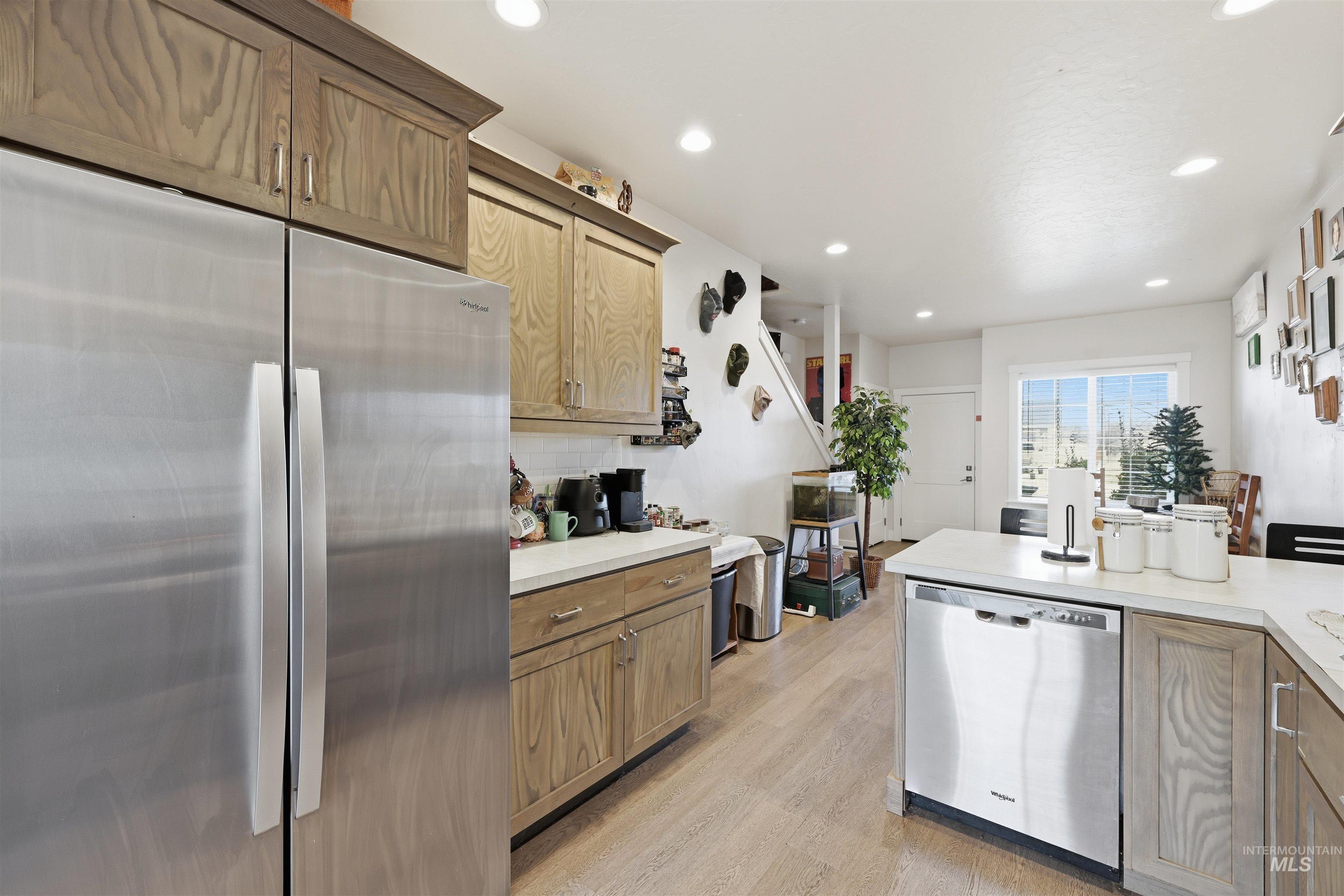 6341 South Ruddsdale Avenue Boise, ID 83709 - Photo 20 of 41 Kitchen featuring appliances with stainless steel finishes, light countertops, recessed lighting, backsplash, and light wood-style floors