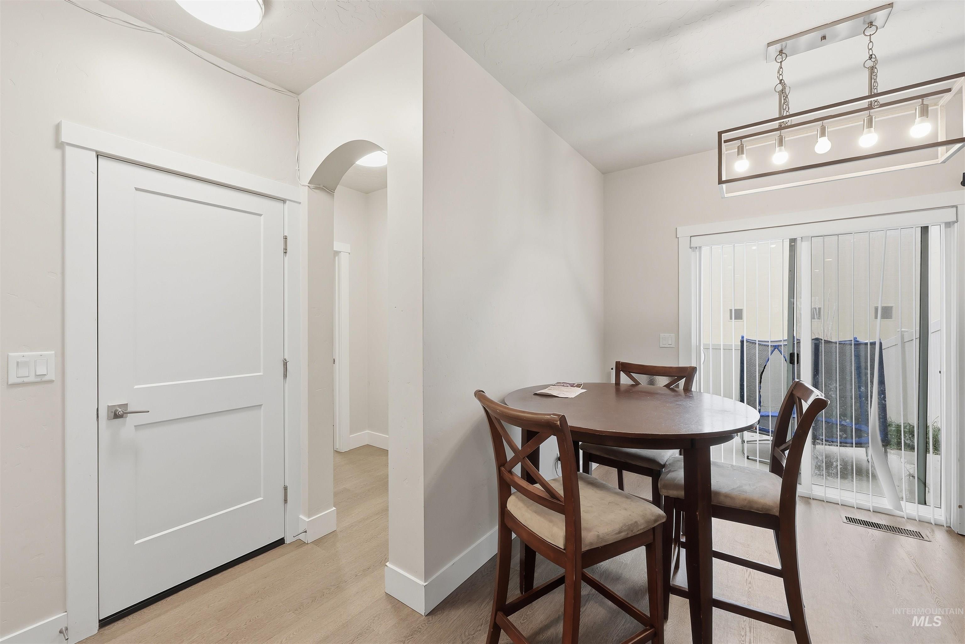 6341 South Ruddsdale Avenue Boise, ID 83709 - Photo 8 of 41 Dining space with light wood-style floors, arched walkways, and rail lighting