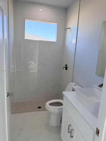 an empty room with a ceiling fan and a window