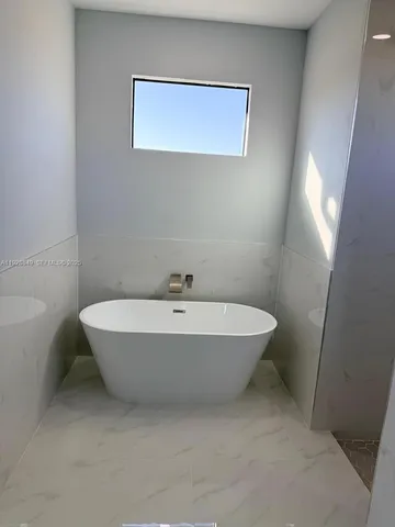 an empty room with windows and ceiling fan