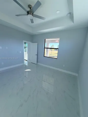 a bedroom with a bed and a flat tv screen on dresser